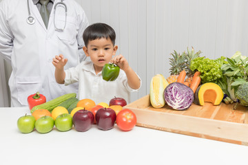 Fototapeta premium Healthy and nutrition concept. Kid learning about nutrition with doctor to choose eating fresh fruits and vegetables.