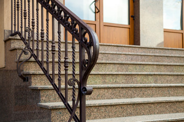 Detail of a house facade. New granite stairs with metal railings.
