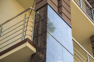 Close up view of part of a building facade with the surface of granite wall. Natural stone materials.