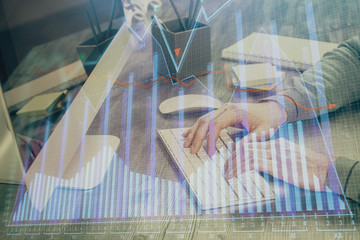 Double exposure of financial graph with man works in office on background. Concept of analysis.