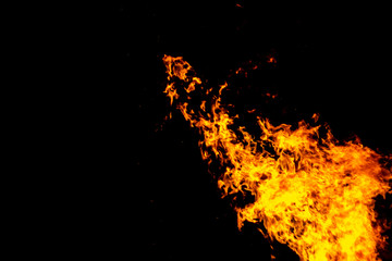 Fototapeta na wymiar Big fire and silhouette of brazier on black background. Flame of fire in dark. Bonfire in barbecue at night. Dance of flame. Form of blaze