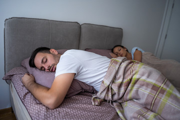 Young couple is sleeping in their bed.