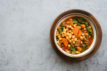 Meat stew in bowl with chickpeas, green Kale and vegetables. Slow cooked seasonal food