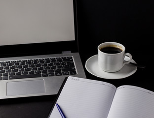 Office desk table with laptop, cup of coffee and other supplies. With copy space