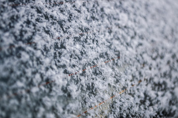 Wet snow on the glass car window, winter background