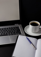 Office desk table with laptop, cup of coffee and other supplies. With copy space