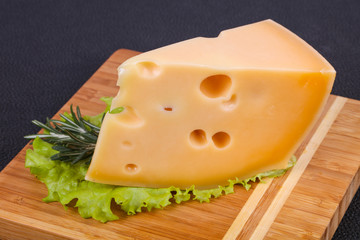 Maasdam cheese  in the board served salad leaves
