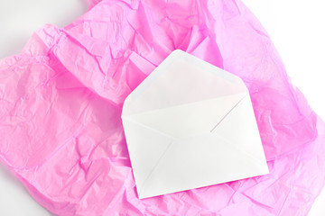 open white envelope on pink background. invitation to a holiday. top view, place for text