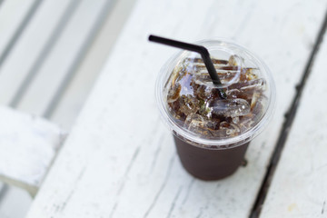 Close up glass of ice americano coffee on wood table, selective focus