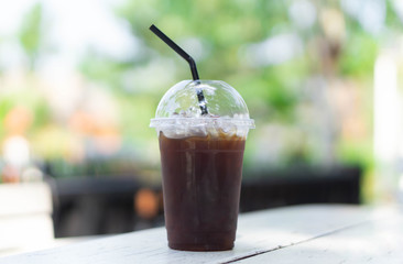 Close up glass of ice americano coffee on wood table, selective focus