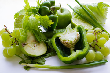 Green vegetables and fruits: cucumber, green onions, bell pepper, cilantro, celery, apples, grapes and lime. Green concept, healthy life, vegetarian, vegan
