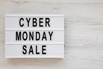 'Cyber monday sale' words on a modern board on a white wooden surface, top view. Overhead, from above, flat lay. Space for text.