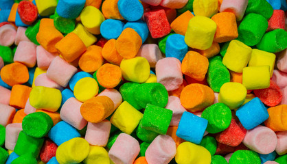 A huge pile of colorful marshmallows red, yellow, orange, green and blue. Colourful candy background