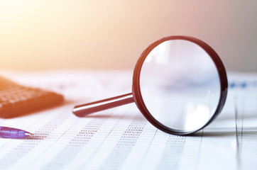 Single Magnifying Glass with Black Handle, Leaning on the financial data. Business and Finance...
