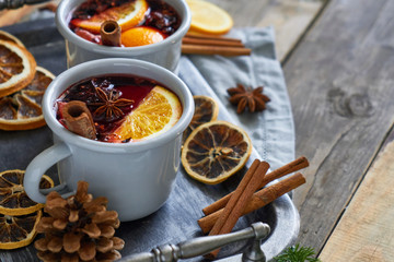 Obraz na płótnie Canvas Two mugs with christmas mulled wine with citrus fruits and spices