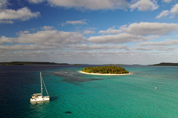 Aerial shot of a scenic landscape of desert island with white sand beach and crystal clear sea water bay. 