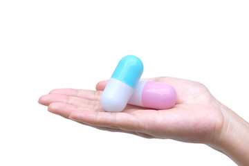 Female hand holding two big capsule medicine islated on white background / Drug overdose concept