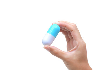 Female hand holding a big capsule medicine isolated on white background / Drug overdose concept