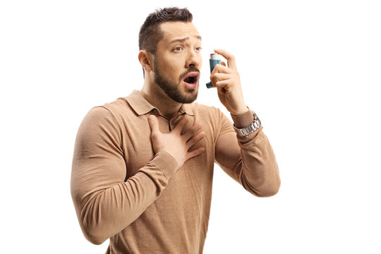 Young man with breathing difficulties using an inhaler