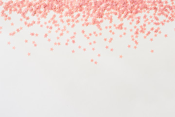 Pastel pink confetti stars on a white background. Holiday Party Concept