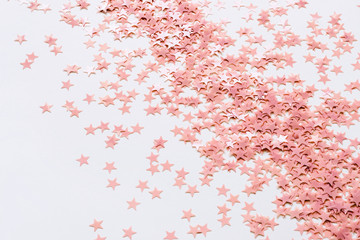 Pastel pink confetti stars on a white background. Holiday Party Concept