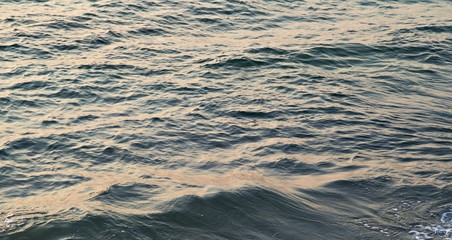 Background texture of a calm deep ocean with ripples on the surface of the sea water ,warm tone color  