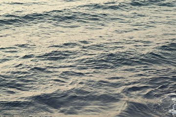 Background texture of a calm deep ocean with ripples on the surface of the sea water ,warm tone color  