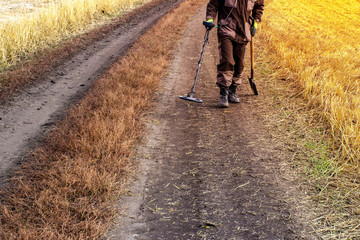 Fototapeta premium a man with a metal detector in search of a treasure