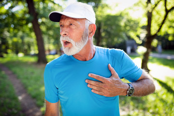 Naklejka na ściany i meble Mature man exercising outdoors to prevent cardiovascular diseases and heart attack