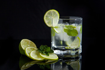 Summer cocktail mojito in glass on black background..