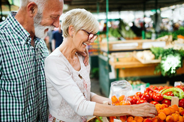 Only the best fruits and vegetables. Beautiful mature couple buying fresh food on market