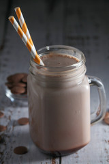 A glass jar with chocolate milk drink	
