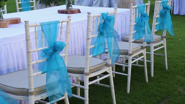 Beauty blue ribbon white wedding birthday party chair moving walking blow by the wind during sunset time in bali indonesia asia