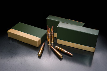 several boxes of ammunition for a carbine or rifle on a dark back