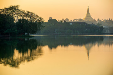 Fototapeta na wymiar Kandawgyi Lake is one of the two major lakes in Yangon, Myanmar, located east of the Shwedagon Pagoda, reflected in the water in the evening. The sky is beautiful orange.