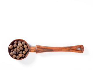 Allspice (Jamaica pepper) in wooden spoon horizontally on white background