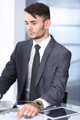 Businessman working with computer in modern office. Headshot of arab male entrepreneur or manager at workplace. Business concept