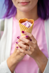 Girl with purple hair in pink t-short holding in her hands violet ice cream