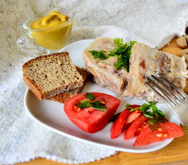 Fototapeta na wymiar Jelly with meat, beef jelly, traditional Russian dish, serving on a plate, mustard, bread, tomatoes. Side light. Close-up.