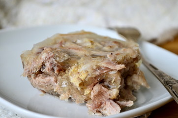 Jelly with meat, beef jelly, traditional Russian dish, serving on a plate, mustard, bread, tomatoes. Side light. Close-up.
