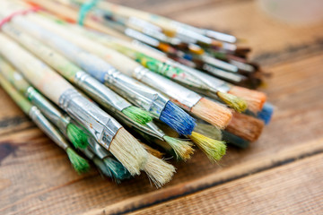 Fototapeta premium A closeup of the few paintbrushes in the wooden table