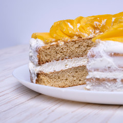 Homemade vegan organic cake. Almond flour and natural cream with mango pieces on top