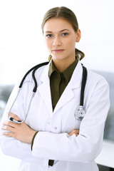 Doctor woman standing straight and looking at camera. Perfect medical service in clinic. Happy future in medicine and healthcare