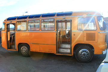 Fototapeta na wymiar yellow old bus with open doors on the street