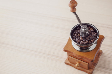 Vintage manual coffee grinder with roasted coffee beans
