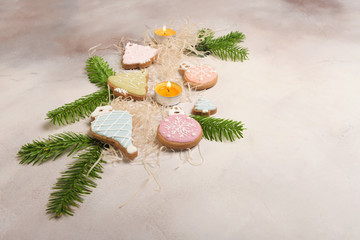 Christmas composition with ginger cookies, candles and spruce branches.