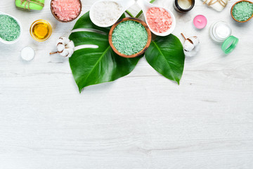 Aromatic colored sea salt on a white wooden table. The concept of cosmetics and spa. Top view. Free copy space.