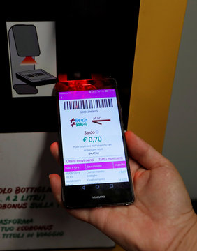A scanner of a recycling machine reads barcode on a smartphone in San Giovanni metro station in Rome