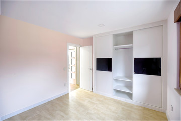 Empty bright bedroom with built-in wardrobes.  Interior modern bedroom.