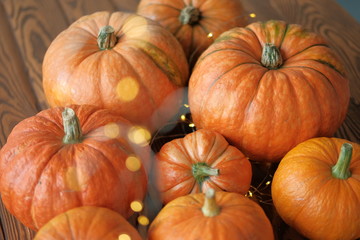 pumpkins with a shining garland on a wooden table